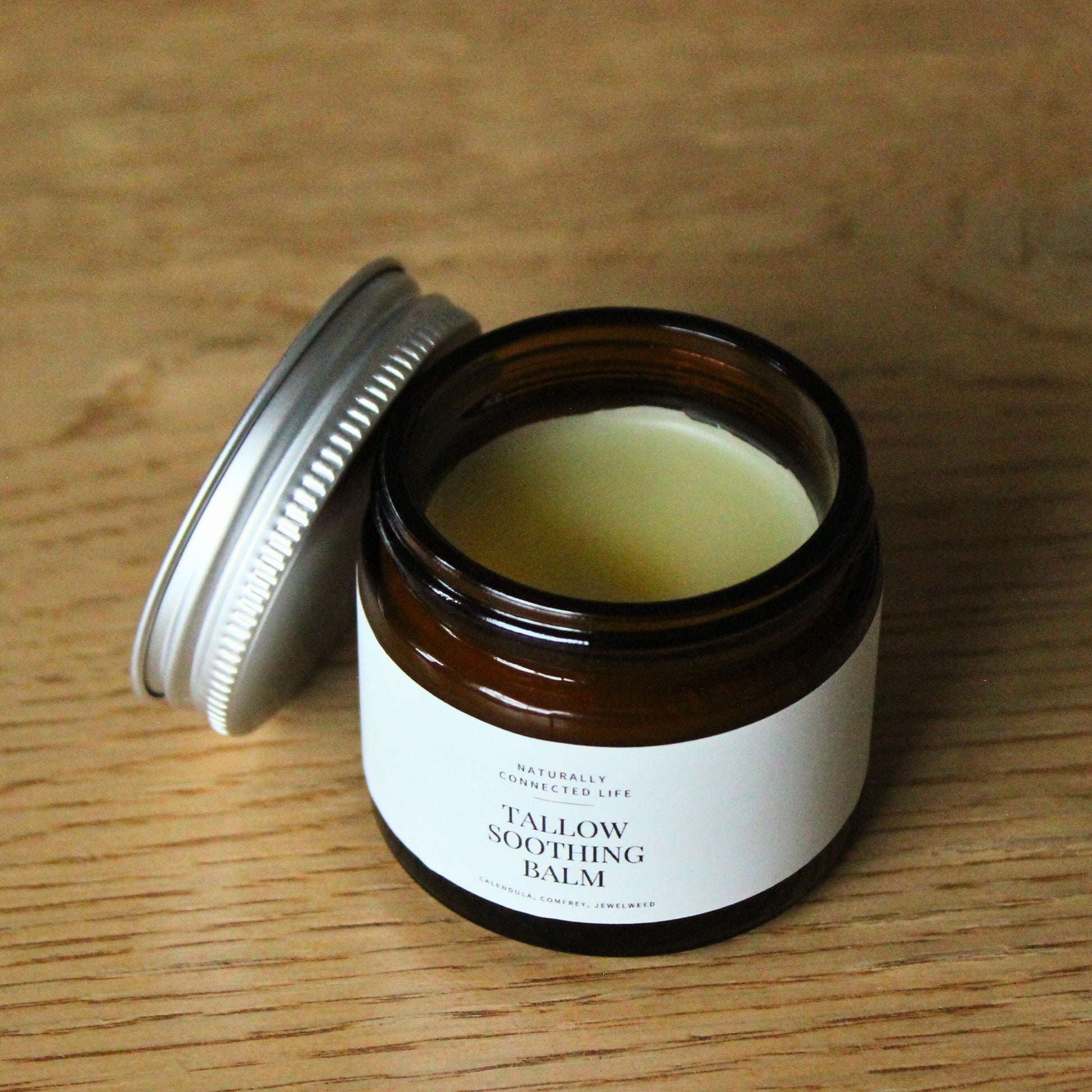 Open jar of Tallow Soothing Balm, grass-fed beef tallow balm to soothe cuts, scrapes, rashes. Healing tallow balm for small cuts. 